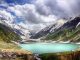 People enjoying a serene lake surrounded by mountains and greenery in Northern Pakistan